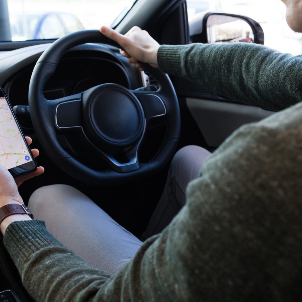 man-using-smartphone-while-driving-car